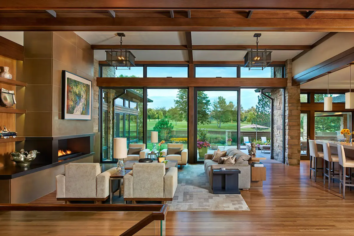 A stylish living room with wooden beams and large windows, offering a beautiful view of the outdoors. This design is perfect for integrating smart home features in a luxurious setting.