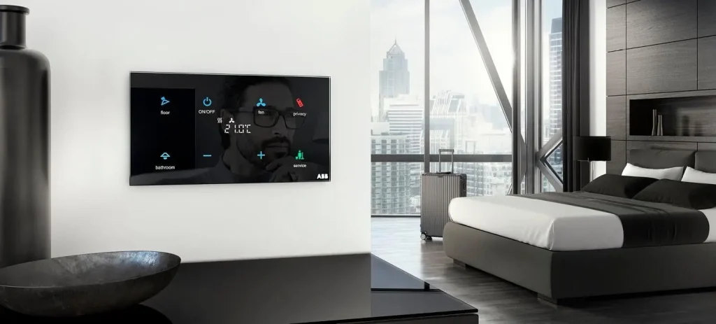 A luxurious hotel room equipped with a Hotel Room Automation System, displaying controls for fan, privacy, lighting, and room services, with a modern cityscape view through large windows.